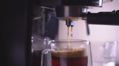 Kahve köpüğüne yakın çekim. Tam otomatik kahve makinesinden çıkan espresso kreması kahve makinesini fincana dönüştürür. yumuşak odak.