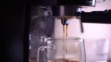 Kahve köpüğüne yakın çekim. Tam otomatik kahve makinesinden çıkan espresso kreması kahve makinesini fincana dönüştürür. yumuşak odak.