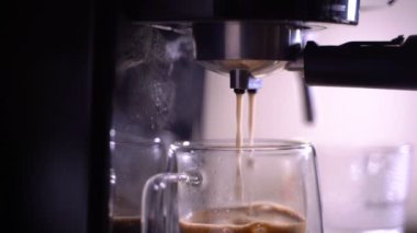 Kahve köpüğüne yakın çekim. Tam otomatik kahve makinesinden çıkan espresso kreması kahve makinesini fincana dönüştürür. yumuşak odak.