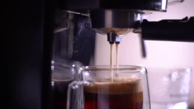 Kahve köpüğüne yakın çekim. Tam otomatik kahve makinesinden çıkan espresso kreması kahve makinesini bir fincana dönüştürür..