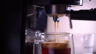 Kahve köpüğüne yakın çekim. Tam otomatik kahve makinesinden çıkan espresso kreması kahve makinesini bir fincana dönüştürür..