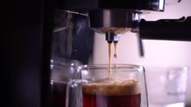 Kahve köpüğüne yakın çekim. Tam otomatik kahve makinesinden çıkan espresso kreması kahve makinesini bir fincana dönüştürür..