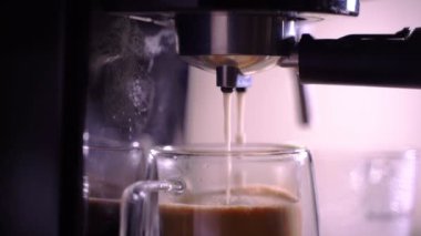 Kahve köpüğüne yakın çekim. Tam otomatik kahve makinesinden çıkan espresso kreması kahve makinesini fincana dönüştürür. yumuşak odak.