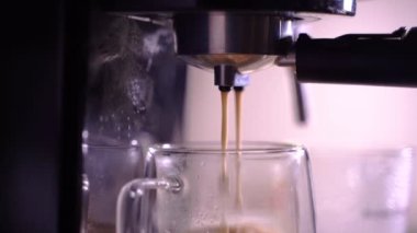Kahve köpüğüne yakın çekim. Tam otomatik kahve makinesinden çıkan espresso kreması kahve makinesini fincana dönüştürür. yumuşak odak.