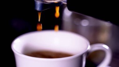 Kahve köpüğüne yakın çekim. Tam otomatik kahve makinesinden çıkan espresso kreması kahve makinesini fincana dönüştürür. yumuşak odak.