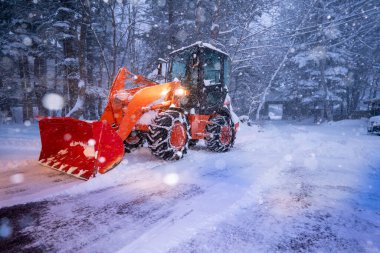 snow shovel tractor on a heavy snowy day at Heike No Sato Village in Tochigi Prefecture, Nikko City, JAPAN. soft focus.