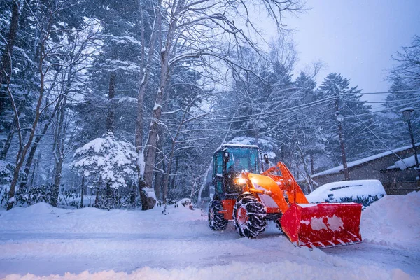 snow shovel tractor on a heavy snowy day at Heike No Sato Village in Tochigi Prefecture, Nikko City, JAPAN. soft focus.