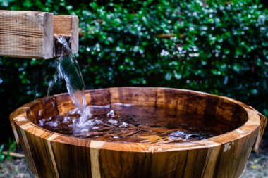Wooden barrels for natural onsen, steam hot water from natural hot springs, soft focus.