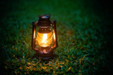 antique oil lamp On the grass in the forest in the evening camping atmosphere.Travel Outdoor Concept image