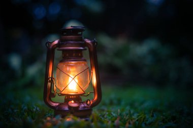 Antik petrol lambası. Ormanın çimlerinde kamp atmosferinde. Açık havada dolaşın.