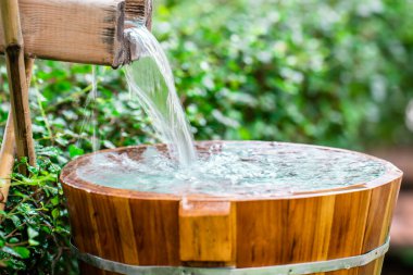 Wooden barrels for natural onsen, steam hot water from natural hot springs, soft focus.