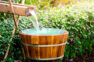 Wooden barrels for natural onsen, steam hot water from natural hot springs, soft focus.