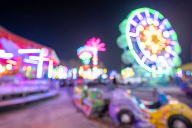 Gece açık hava eğlence parkında renkli ışıklar, tapınak fuarı geleneksel bir festival, dini törenler için bir yer ve yerel bir tema parkı var.. 