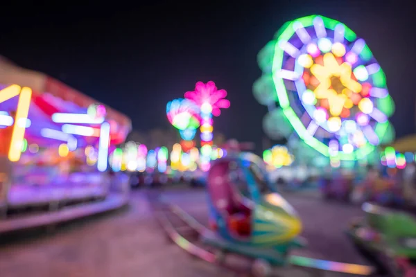 Gece açık hava eğlence parkında renkli ışıklar, tapınak fuarı geleneksel bir festival, dini törenler için bir yer ve yerel bir tema parkı var.. 