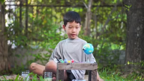 太陽系のおもちゃ 感覚活動 家庭での学習ツールを着色する集中アジアの少年 — ストック動画