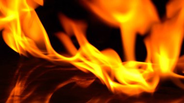 Alevin yakma gücü, alevler ve yakın çekim kıvılcımları, ateş desenleri, karanlığın parıltısı. yumuşak odak.