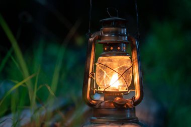 Ormanın eski ahşap zemininde antika bir gaz lambası gece kamp atmosferinde