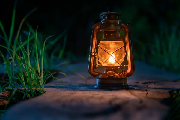 Ormanın eski ahşap zemininde antika bir gaz lambası gece kamp atmosferinde