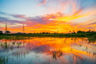 Tayland kırsal kesimlerinde yüksek voltaj direği portakal rengi güneş doğumu arka planı