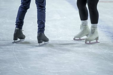 Açık havada buz pateni pistinde paten yapan genç bir kız, açık alanda buz pateni yapmayı düşünüyor.