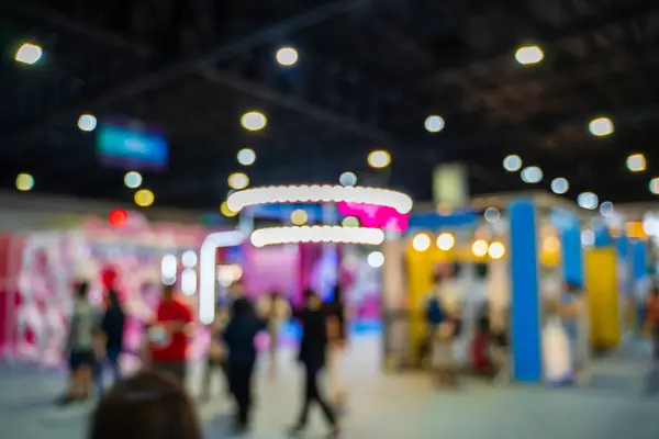Blurred images of trade fairs in the big hall. image of people walking on a trade fair exhibition or expo where business people show innovation activity and present products in a big hall.