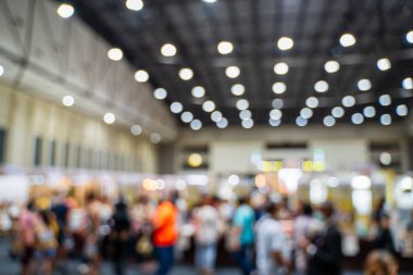Büyük salondaki ticaret fuarlarının bulanık görüntüleri. Ticaret fuarı ya da fuarında yürüyen insanların imajı iş adamlarının büyük bir salonda yenilik faaliyetleri ve sunum ürünleri sergilediği bir sergi..