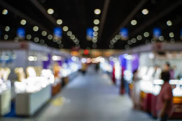 Blurred images of trade fairs in the big hall. image of people walking on a trade fair exhibition or expo where business people show innovation activity and present products in a big hall.