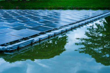 Gölde suyun üzerinde yüzen güneş panellerinin yan görünüşü, güneş ışığından elektrik üretmek, seçici odak, yumuşak odak.