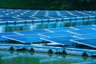 Gölde suyun üzerinde yüzen güneş panellerinin yan görünüşü, güneş ışığından elektrik üretmek, seçici odak, yumuşak odak.