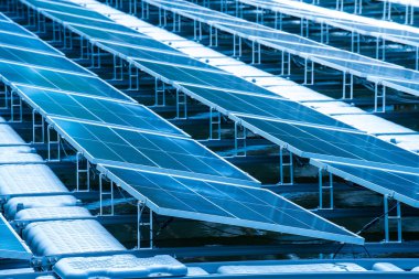 Gölde suyun üzerinde yüzen güneş panellerinin yan görünüşü, güneş ışığından elektrik üretmek, seçici odak, yumuşak odak.