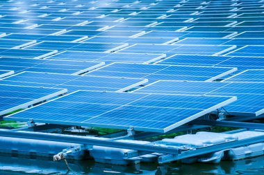 Gölde suyun üzerinde yüzen güneş panellerinin yan görünüşü, güneş ışığından elektrik üretmek, seçici odak, yumuşak odak.