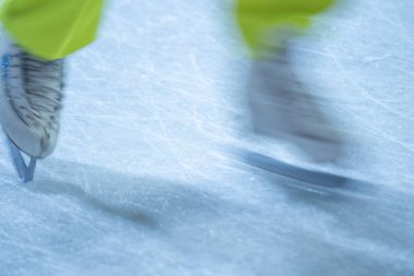 Açık hava buz pistinde paten hareketleri bulanıklaştı. Açık alanda paten yapan genç bir kız.