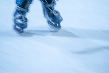 Açık hava buz pistinde paten hareketleri bulanıklaştı. Açık alanda paten yapan genç bir kız.