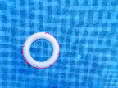 Mavi yüzme havuzunda yüzen can simidinin üst görüntüsü, yumuşak odak.