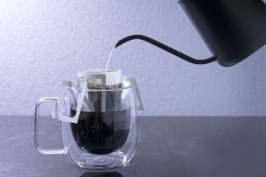 Kahveyi damlat ve siyah taş masaya su dök, yumuşak odaklanma. Sığ odak etkisi.