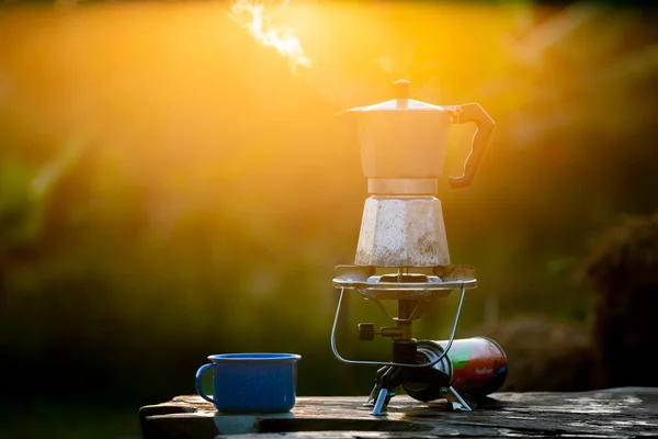Moka pot and smoke, Steam from the coffee pot on fire, In the forest at sunrise in the morning. soft focus. shallow focus effect.