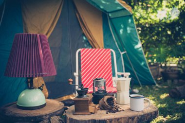 Eski ahşap masa üzerinde antika kabin çadırı, antika yağ lambası, retro sandalyeler, kamp çadırları grubu ve yumuşak odak.