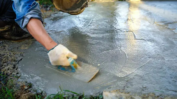 stock image Bricklayer laying concrete To create a cement floor inside the house, soft focus