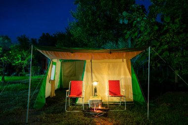 Gece çadırı, eski çadır, antika gaz lambası, retro sandalye, gece ormanlarında şenlik ateşi..