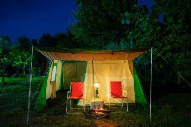 Gece çadırı, eski çadır, antika gaz lambası, retro sandalye, gece ormanlarında şenlik ateşi..