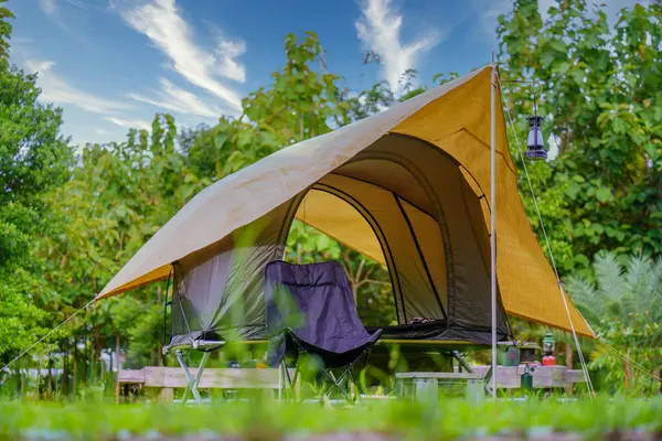 Kamp çadırları, antik fenerler, retro sandalyeler ve ormandaki masalarda açık kahve yapma tesisleri.