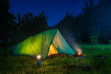Geceleri kamp çadırları ve kamp alanında açık kahve yapma tesisleri.