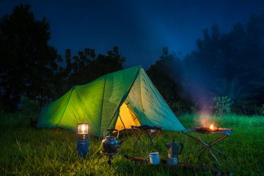 Geceleri kamp çadırları ve kamp alanında açık kahve yapma tesisleri.