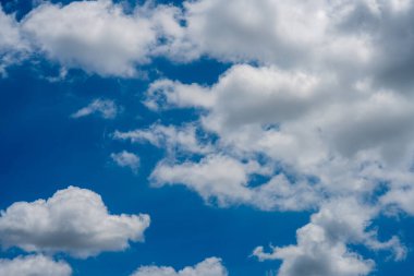 Parlak mavi gökyüzü beyaz kabarık bulutlar ile