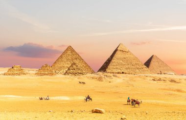 Mısır Piramitleri gün batımında turistlerle birlikte, Giza Çölü, Kahire.
