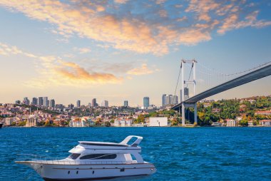 İstanbul 'da Boğaziçi Köprüsü ve Beşiktaş manzaralı yat.