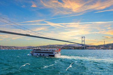 Yolcu gemisi İstanbul, Türkiye 'de Boğaziçi Köprüsü, Günbatımı manzarası altında yol alıyor.