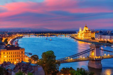 Gün batımında Budapeşte 'nin panoramik akşam manzarası Parlamento binası, Zincir Köprüsü ve Tuna Nehri.