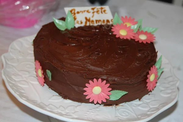 ホワイトプレートに花のチョコレートケーキ — ストック写真