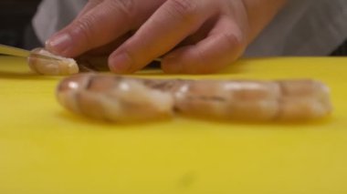 Şef, sarı bir tahtada şefin bıçağıyla şerit kesiyor. Yakın çekim..